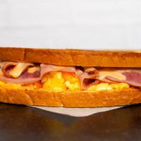 Sourdough, Ham, Egg, & Cheddar Sandwich · 2 scrambled eggs, melted Cheddar cheese, sliced ham, and Sriracha aioli on buttery toasted s...