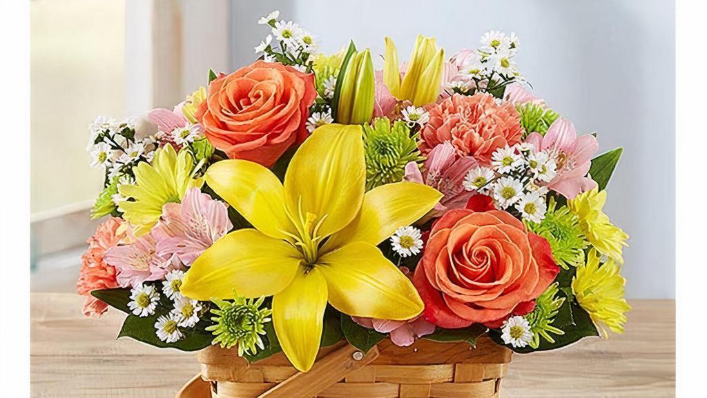 Fields Of Europe™ Basket · A delightful bouquet that reminds one of freshly picked flowers. It includes orange roses and carnations; yellow Asiatic lilies and daisy poms; pink Peruvian lilies (alstroemeria); Athos poms; white monte casino; accented with salal tips Artistically designed in a split wood handled basket with liner.