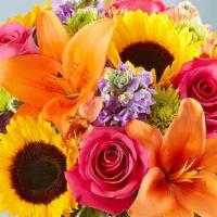 Floral Embrace  · All-around arrangement of hot pink roses and carnations; orange Asiatic lilies and Peruvian ...