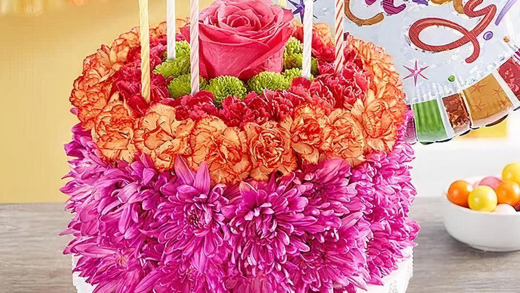 Birthday Wishes Flower Cake® Vibrant · Our vibrant new flower cake has all the ingredients for a happy celebration: hot pink and fiery orange blooms—and candles to top it off.  Make their birthday their best day yet with this arrangement