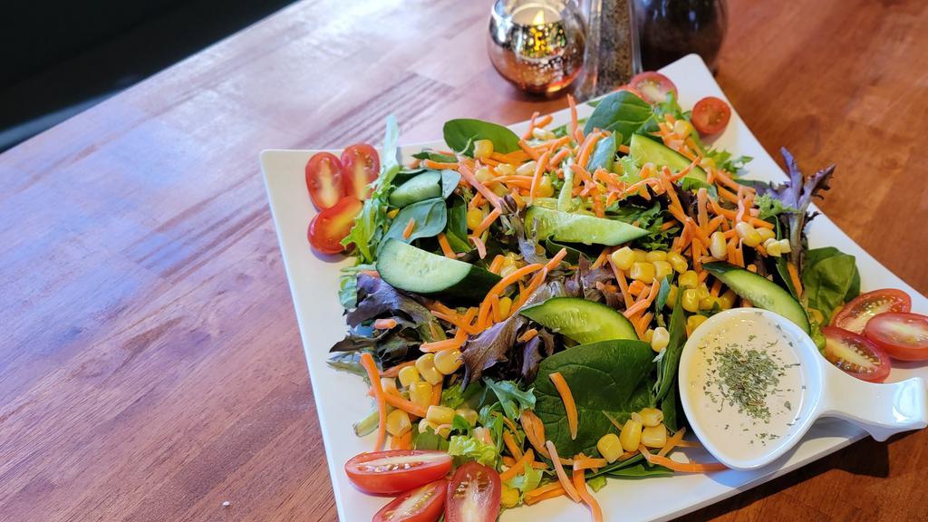 Garden Salad · Fresh organic mixed greens, cucumbers, corn, carrots, tomatoes, and our special house dressing.