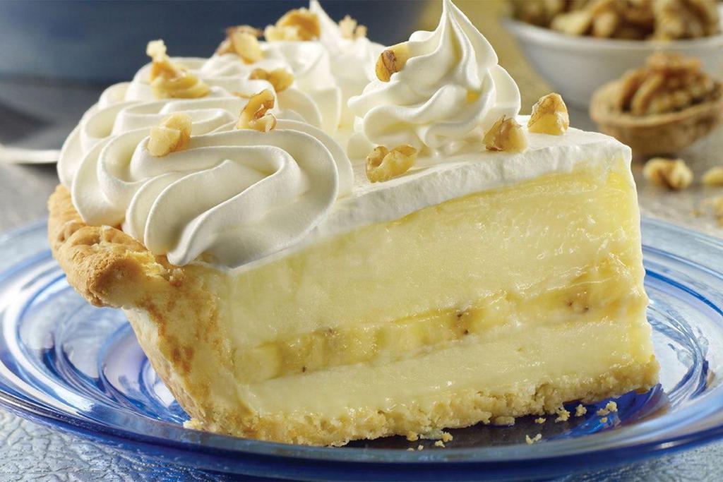 Banana Cream Pie · This slice of gold is filled with fresh bananas folded into sweet vanilla cream, topped with whipped cream and walnuts.