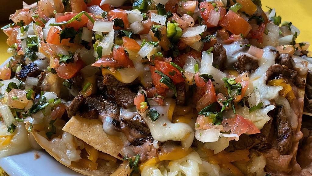 Vallejo'S Nachos · Crispy tortilla chips smothered with refried beans, melted Jack and Cheddar cheese and choice of chicken, carne asada (steak) or carnitas (pork) topped with guacamole, sour cream and pico de gallo, large nacho includes lettuce. Grilled shrimp with additional cost.
