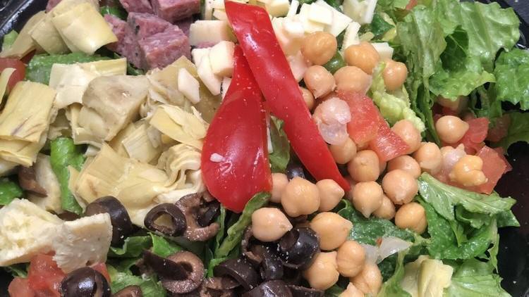 Chopped To Perfection · Romaine lettuce, tomatoes, red bell pepper, jack cheese, black olives, marinated artichoke hearts, green onions, garbanzo beans and Genoa salami. Tossed with our homemade Italian dressing.