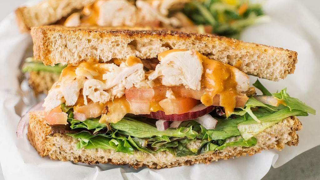Chipotle Chicken Sandwich · Pulled rotisserie chicken, melted white cheddar cheese, and chipotle sauce, mixed greens, tomatoes, onions, served on grilled wheat bread.