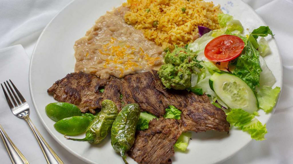 Carne Asada · Tender sliced beef topped with sautéed onions. Served with lettuce, guacamole & pico do gallo.