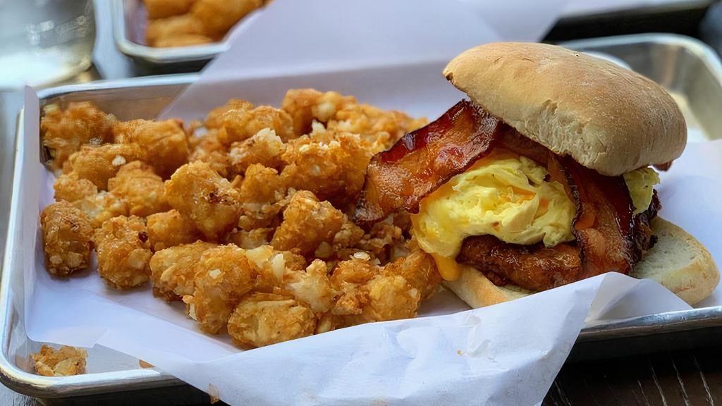 All Day Breakfast Sandwich · 1/4lb breakfast pork sausage, scrambled egg, cheddar cheese, and 2 slices of bacon in-between a toasted ciabatta bun. Severed with Tots