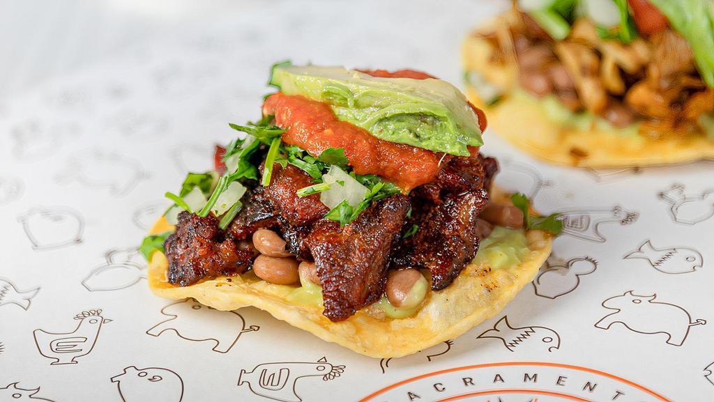 Tostada · Enjoy your choice of Chando’s signature meat selection topped with fresh cilantro, delicious diced onions, creamy guacamole, and house made salsa, fresh sliced avocado served on top of a crispy corn tortilla.