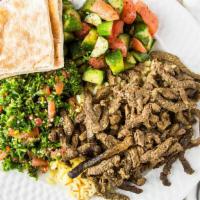 Beef Shawerma · Seasoned beef wrapped in pita bread, pickles, Mediterranean salad, hummus, and tahini sauce.