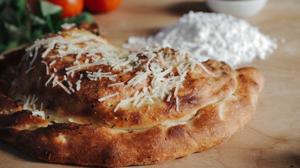 Supreme Calzone · Mozzarella, pepperoni, Italian sausage, mushrooms, green peppers, red onions, and a side of marinara sauce.