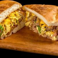 Machaca Torta · Egg, shredded beef, onion, bell pepper, tomato, refried beans, and cheese.