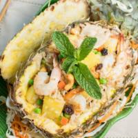 Kao Ob Sup Pa Rod Pineapple Fried Rice · Fried rice mixed with shrimp, chicken, cashew nuts, carrots, peas and raisins, served in a h...