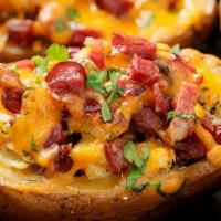 Potato Skins · Potato skins topped with cheese and crispy smoked bacon bits. Served with sour cream and gre...