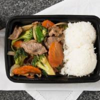 Beef And Broccoli · Stir fried beef with broccoli, carrots, garlic, onions, carrots. Served with steamed, white ...