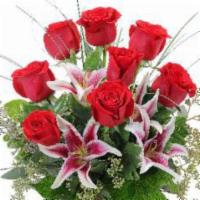 Loving Gaze · Elegant lilies beautifully arranged with red roses in a red vase. Perfect gift to express yo...