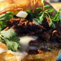 La Birria Burger · Toasted bun, Habanero aioli, Angus beef patty, Oaxaca cheese, Braised birria, Onions, Cilant...