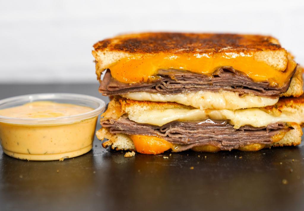 Roast Beef & Three Cheese Melt · Roast Beef, Cheddar, Swiss, and Parmesan cheeses melted between buttery, toasted sourdough bread. Served with a side of Spicy Honey Mustard Aioli.