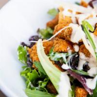Crispy Chicken Salad · Crisp salad made with chicken strips, tomatoes, olives, and red cabbage over a bed of fresh ...