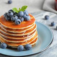 Blueberry Pancakes · 2 fluffy, freshly made pancakes with blueberries.