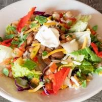 Taco Salad · Crisp salad greens, homemade tortilla chips, pinto beans, sour cream, jack and cheddar chees...