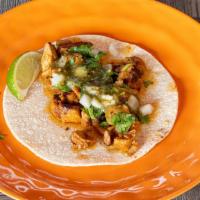 Taco Al Pastor · Pork slowly simmered in Mexican spices, citrus juices and pineapple. Topped with onions, cil...