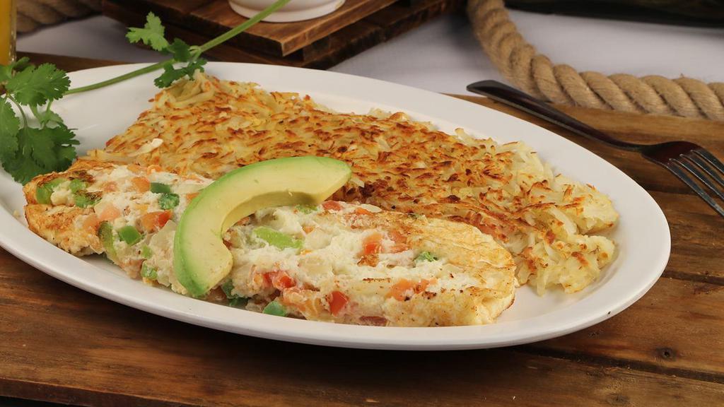 Veggie Omelette · Hearty omelette stuffed with bell peppers, onion, tomato and shredded cheddar cheese. Topped with a fresh slice of avocado and American cheese.