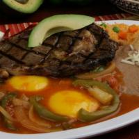 Huevos A La Rodeo · One juicy Rib-Eye beef steak and two eggs served on a corn tortilla topped with salsa and av...
