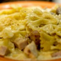 Farfalle Gratinate · Butterfly pasta with cream, mushrooms, ham, pancetta, chicken, and a cheese crust.