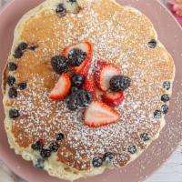 Blueberry Pancakes · 3 blueberry pancakes with Strawberry, banana, blueberry, and powder sugar.