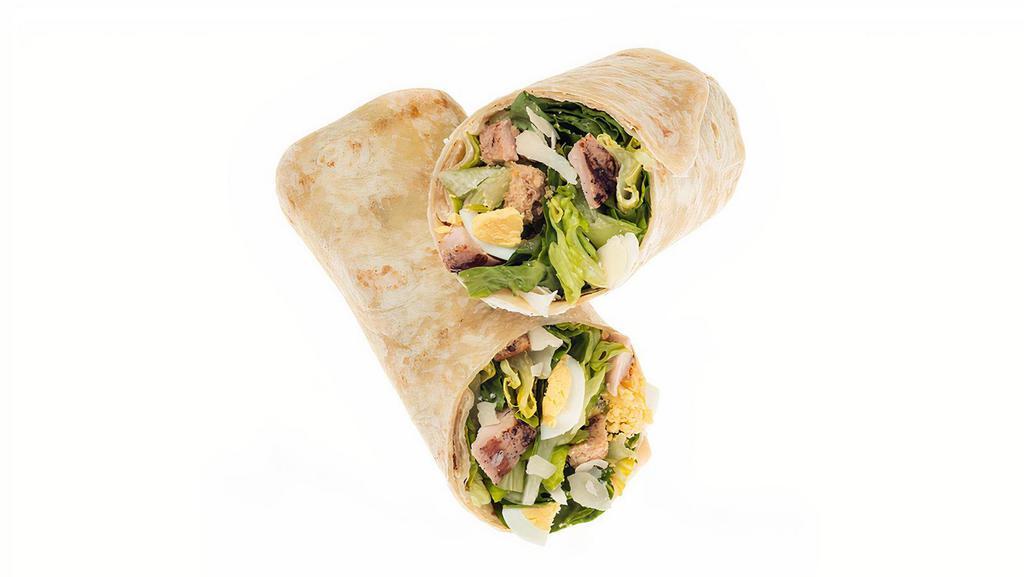 Chicken Caesar Wrap · Our Grilled Chicken Caesar wrap on a flour tortilla comes recommended with a base of Romaine/Iceberg Blend. It is served with Grilled Chicken, Sliced Egg, Parmesan Cheese and Housemade Croutons. We recommend our Classic Caesar dressing.
