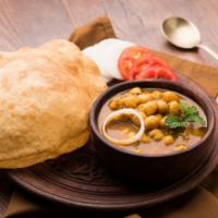 Chole Bhature · Garbanzo beans cooked in curry with herbs, served with deep-fried leavened bread called puri.