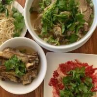 Pho Bistro · Pho dac biet with ribeye steak strip with a side order of rib bones in a rich beef broth wit...