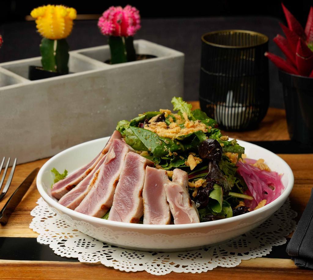 Yellowfin Tuna Salad · Pan seared with brown rice, mixed greens, avocado, pickled red onions, crispy onions, sesame seeds, Asian dressing.