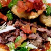 Surf & Turf Tacos (À La Carte) · Marinated steak asada and chimichurri crispy shrimp, melted cheese, guacamole and slaw on co...