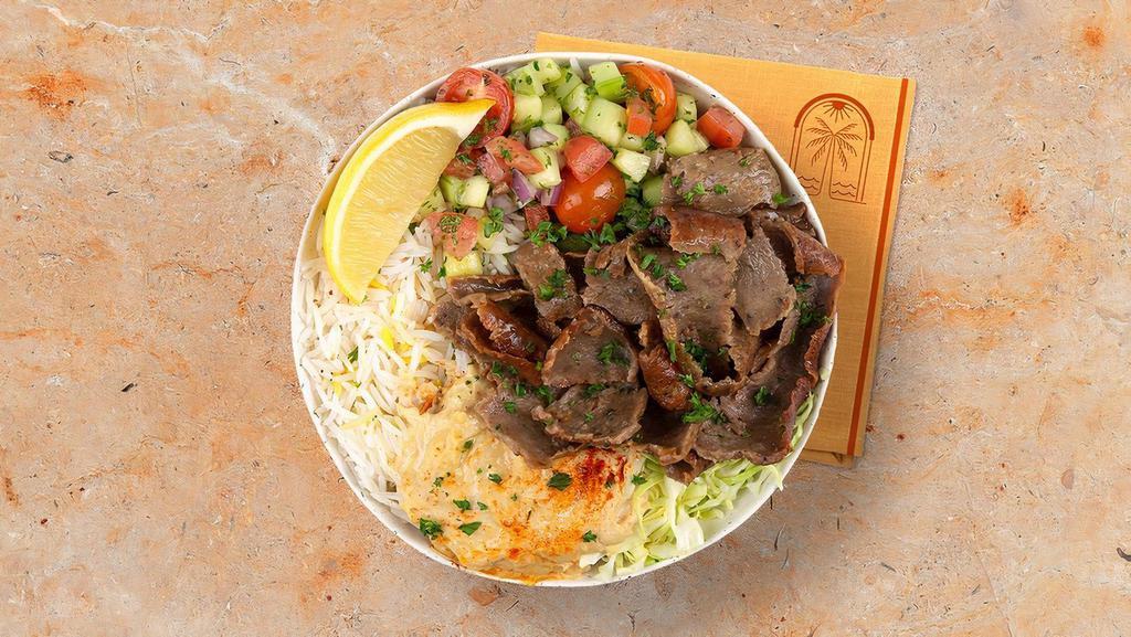 Beef And Lamb Gyro Rice Bowl · Marinated beef and lamb over basmati rice with hummus, diced cucumber and tomato salad, shredded green cabbage and a drizzle of tahini sauce.
