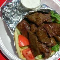 Gyro Sandwich · Grilled pita bread slathered in our decadent garlic sauce and piled high with gyros, onions,...