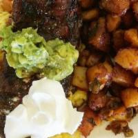 Rancher Cut Steak · Hanger steak, topped with home-made guacamole, salsa and sour cream on a bed of scrambled eg...