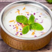 Raita · Freshly prepared fresh yogurt with cucumber, carrot, tomatoes, red onions and herbs.