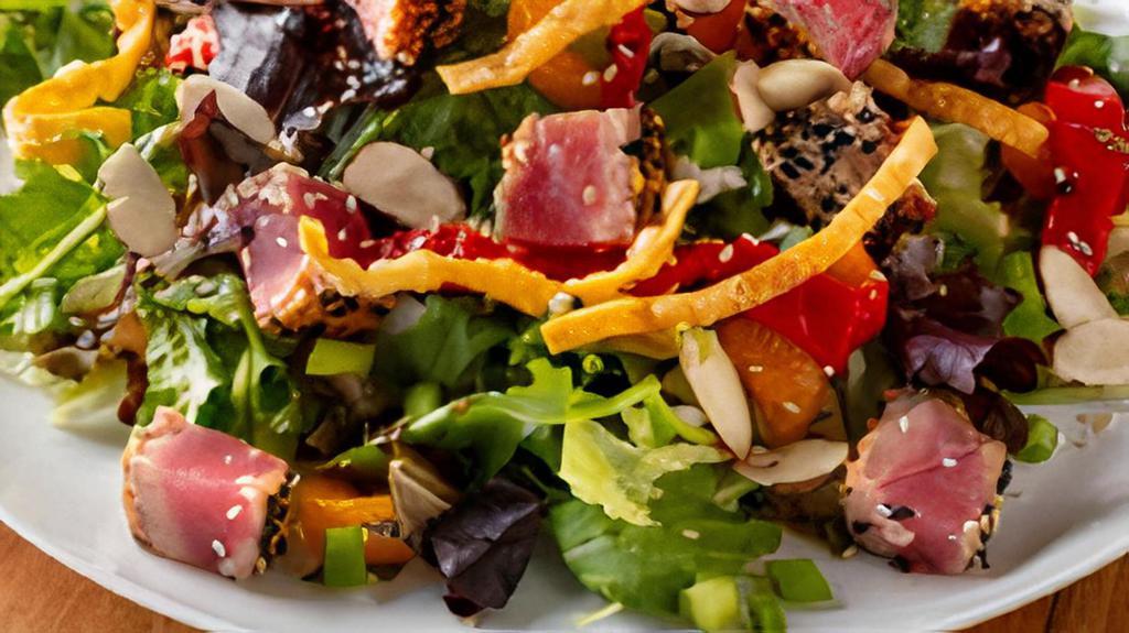 Seared Sesame Crusted Ahi Salad · Tuna seared rare over mixed greens with green onion, roasted peppers, toasted almonds, mandarin oranges, and crispy wonton strips with sesame ginger dressing.