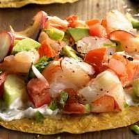 Tostada Ensalada De Camarones · Grilled shrimp, lettuce, black beans, herb rice, guacamole, sour cream, pico de gallo, serve...