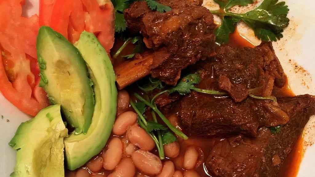 Costillas Al Horno · Tender beef short ribs spiced and slow-baked in our top-secret los panchos family recipe sauce. Slides right off the bone! Served with Spanish rice, refried beans and tortillas.
