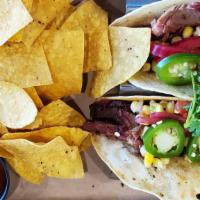 2 Smoked Brisket Tacos · Smoked brisket, pickled red onion, cotija cheese, onion cilantro, cowboy sauce and fresh jal...