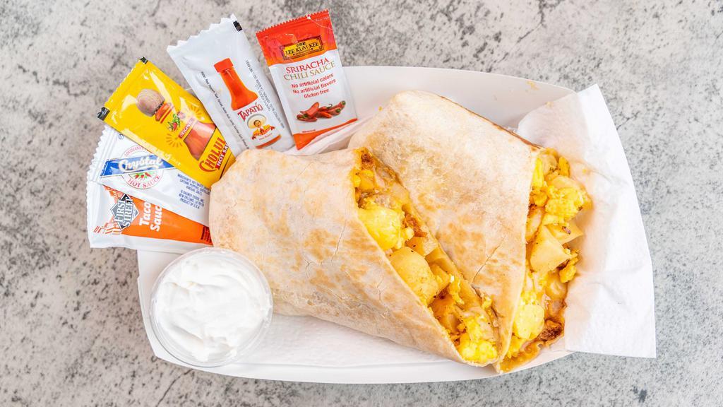 Breakfast Burrito · Our BOMB Breakfast Burritos are loaded with potatoes, eggs, cheese, bacon, ham, sausage/chorizo. They're HUGE at  20+ ounces in size.  *Unable to add or delete ingredients.