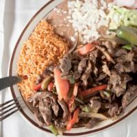 Steak Fajitas · Slices of steak grilled with bell peppers, onions, tomatoes and served with rice, beans, gua...