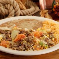 Huevos Con Machaca · Shredded meat with eggs onions tomatoes bell peppers and served with rice beans and tortillas.