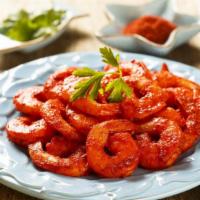 Tandoori Prawns · Sweet water prawns barbecued with herbs and spices over a fresh bed of onions.