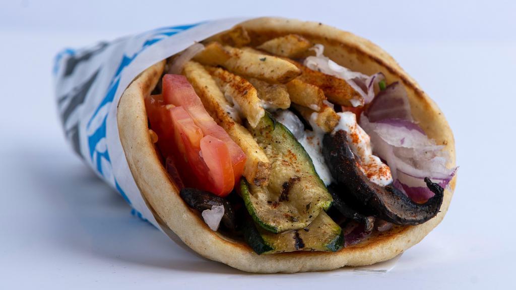Veggie Pita · Grilled zucchini and mushrooms served on a served on a warm pita bread filled with fries, tomatoes, onions and tzatziki sauce.