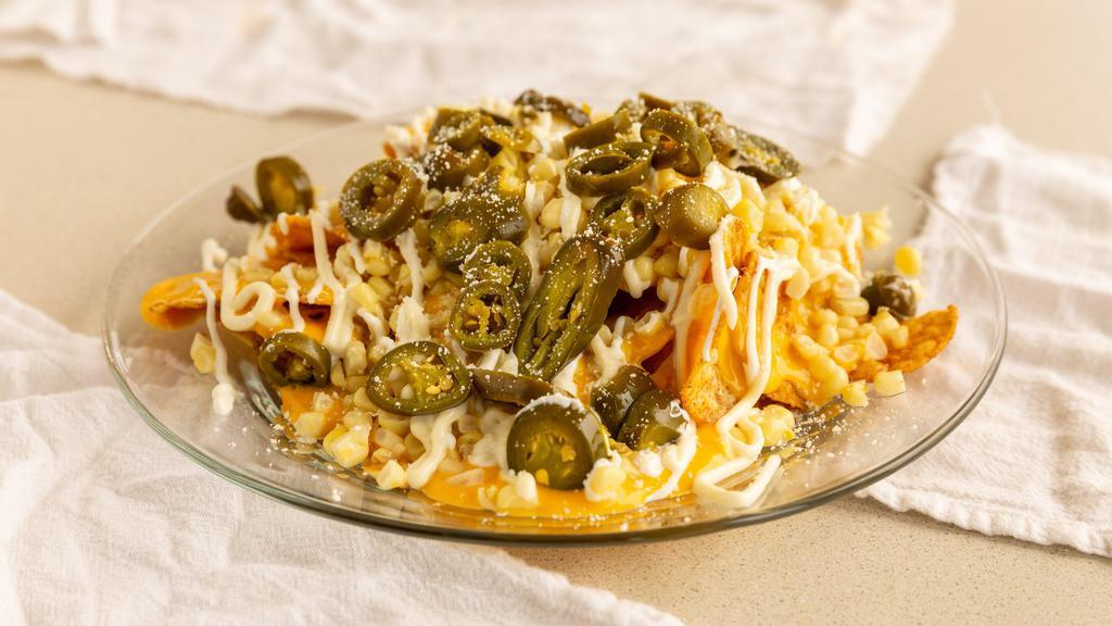 Tostielotes · Tostito chips with nacho cheese, corn, sour cream, mayo, cotija cheese, and jalapenos.