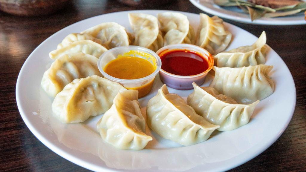 Chicken Momo (10 Pieces) · Steamed dumplings filled with minced chicken, onion, cilantro and spices. Served with special Himalayan sauce.