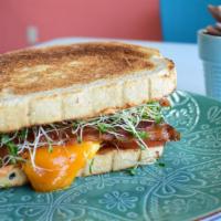 Breakfast Sandwich · Scrambled eggs, cheddar cheese, chipotle aioli, tomato, choice of bacon or sausage served on...